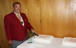 Choir president cutting one of two cakes.JPG